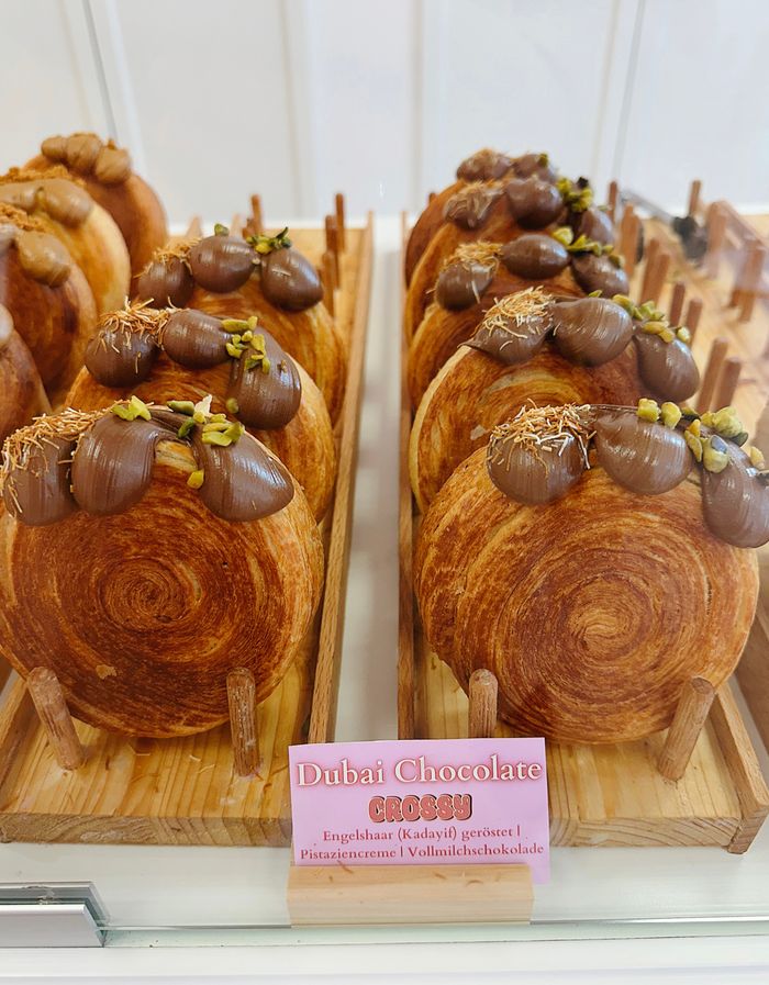 Croissants topped with chocolate and crushed pistachio