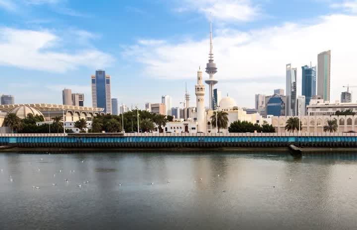 Kuwait City’s waterfront with a white mosque, the Liberation Tower and office towers rising behind a blue sea wall